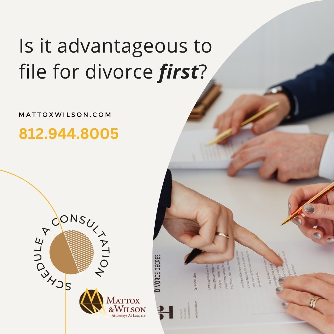 hand pointing to divorce documents with two people signing the documents